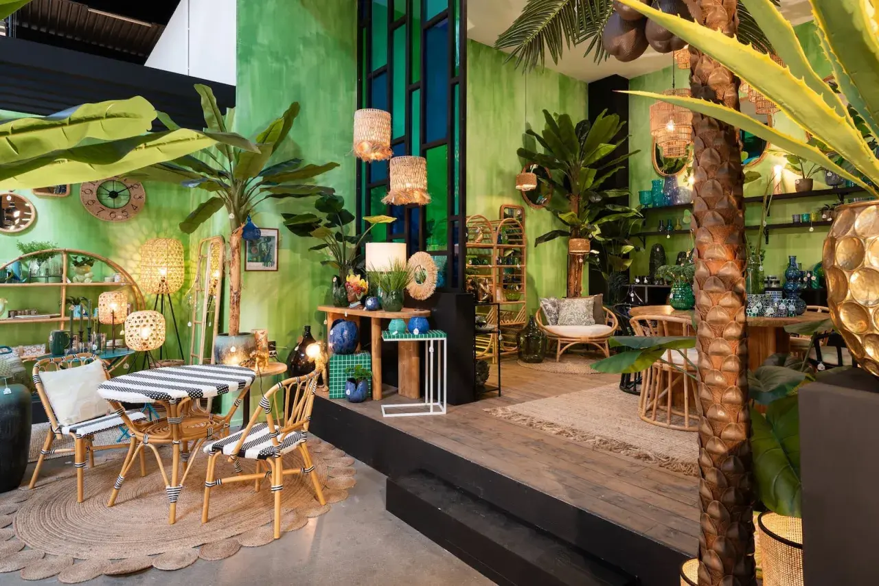 Un salon jungle chic avec des plantes luxuriantes, des meubles en rotin et des touches de bleu et d'or.