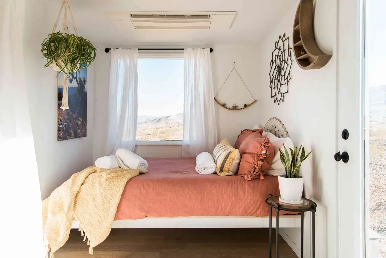 Une chambre d'amis polyvalente avec un lit confortable, des plantes vertes et une vue désertique.