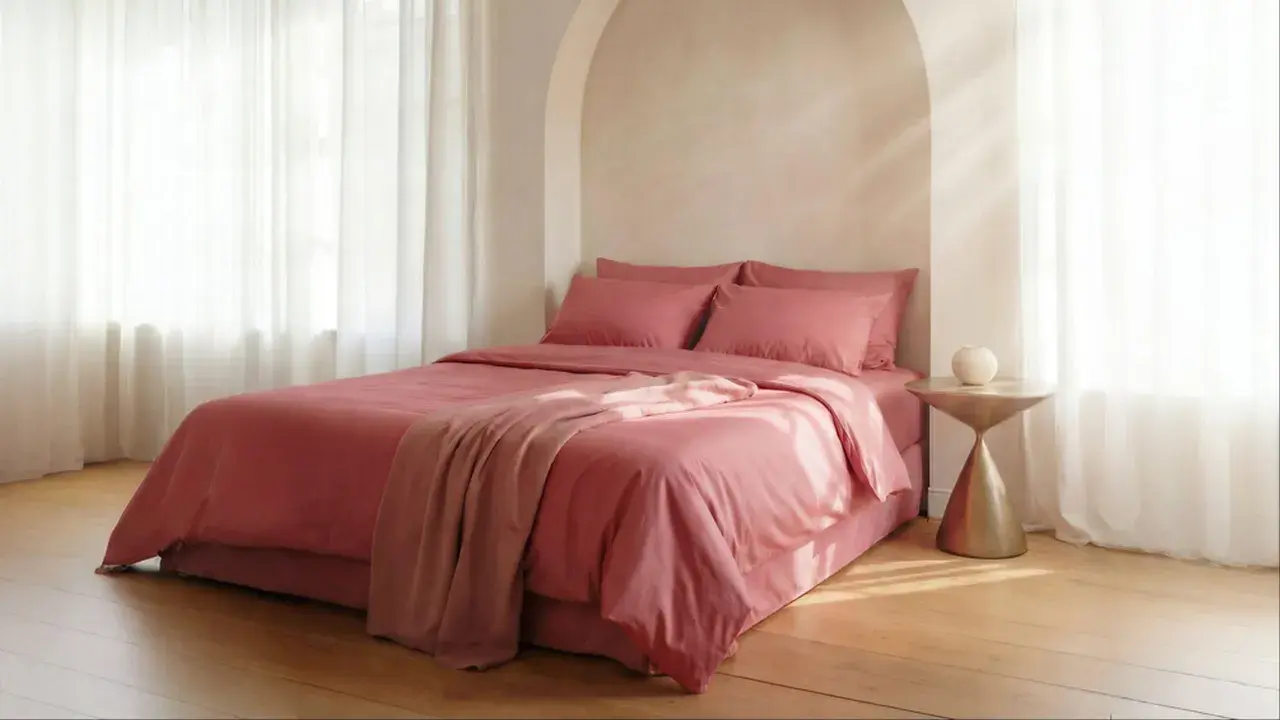 Lit rose avec couvre-lit et coussins. Le polycoton, malgré son aspect doux, peut avoir un inconvénient : il retient la chaleur.