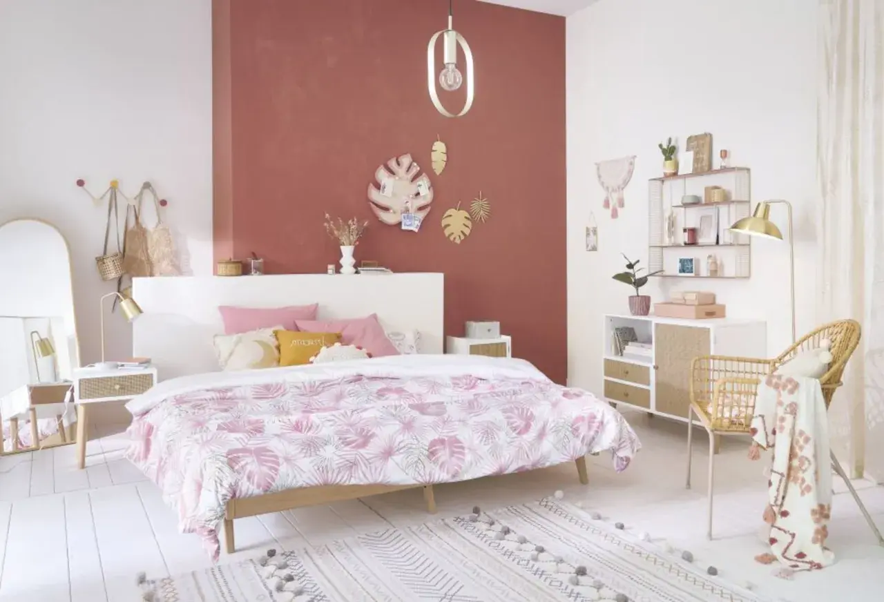 Chambre rose et vert adulte, avec un lit douillet, des touches végétales et une décoration murale tendance.