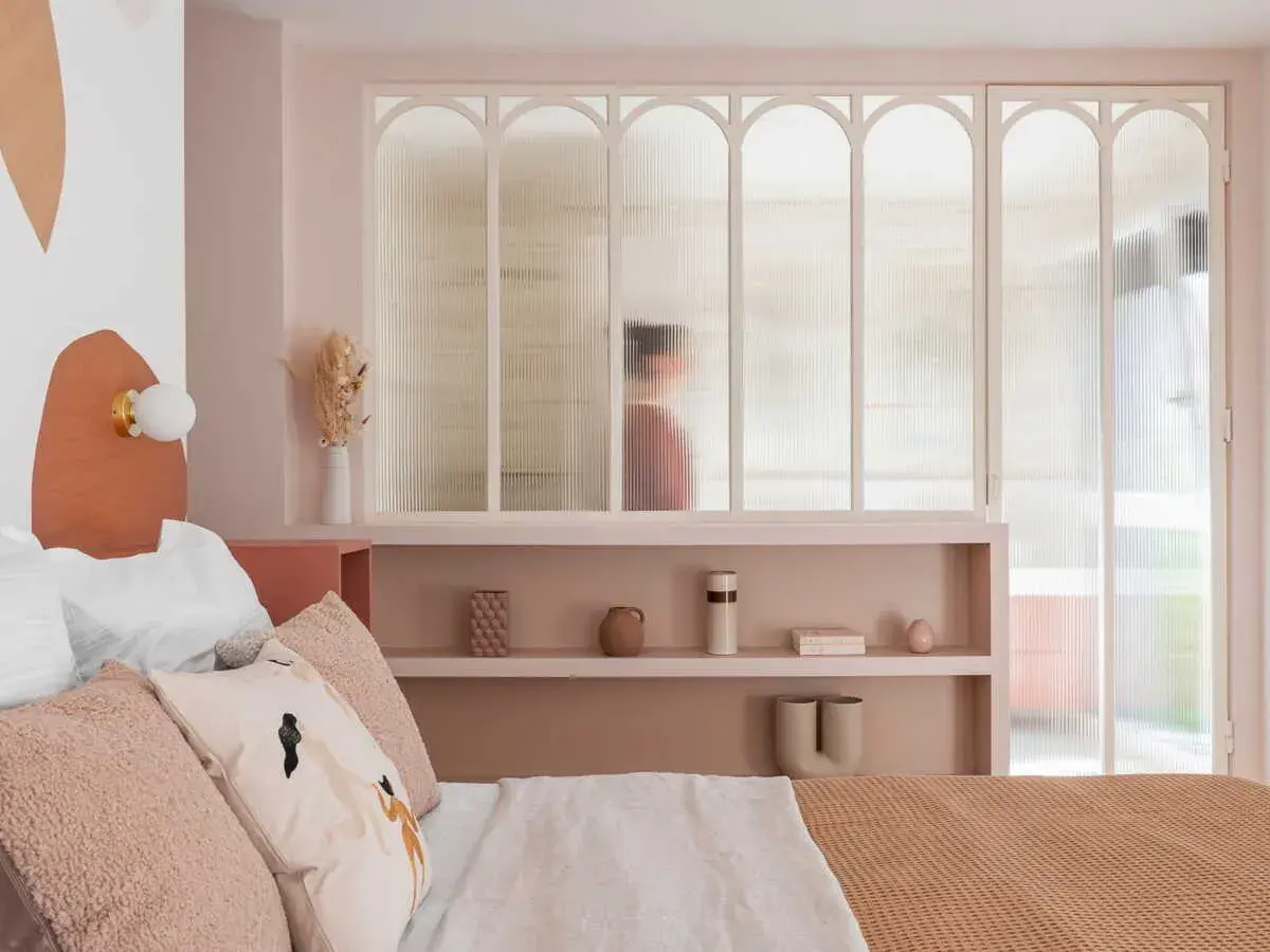 Idées pour comment décorer sa chambre : une chambre douce aux tons pastel, avec une tête de lit originale et des étagères décorées.