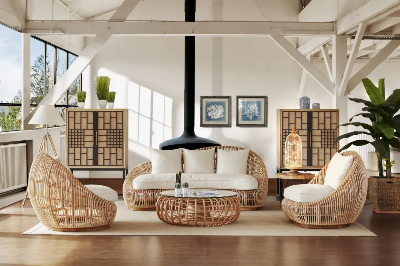Ambiance cosy avec cette idée déco salon rotin : fauteuils enveloppants, canapé, table basse et meubles de rangement en rotin naturel.