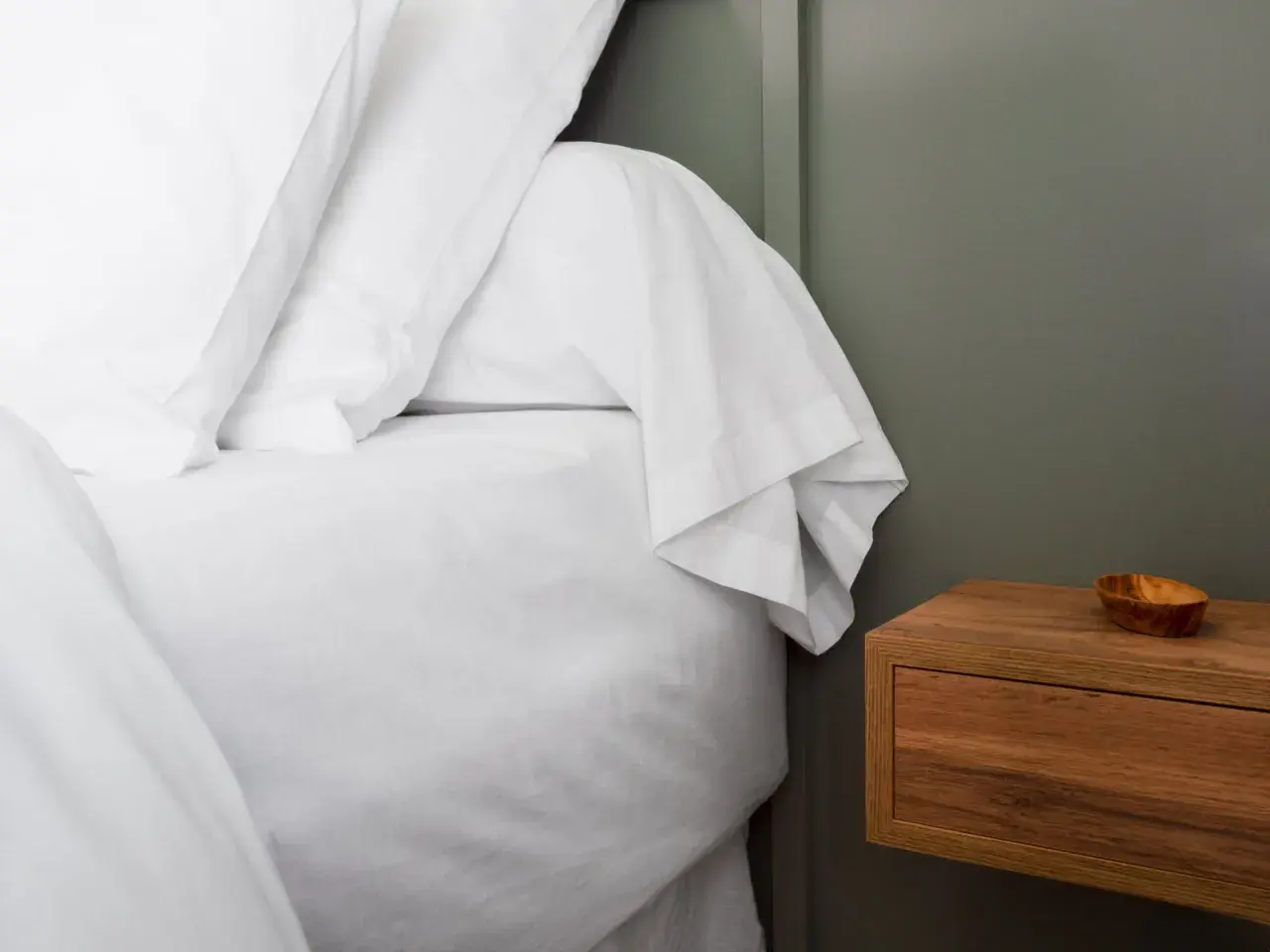 Un lit blanc immaculé avec un drap housse bien ajusté, prêt pour une nuit paisible. C'est quoi un drap housse ? C'est ce qui protège votre matelas.