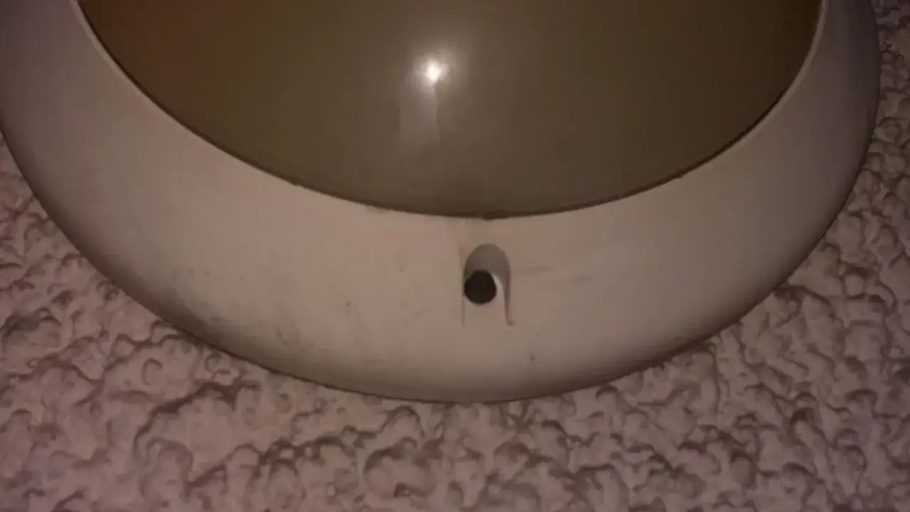 Applique murale ronde blanche avec un trou pour changer l'ampoule.