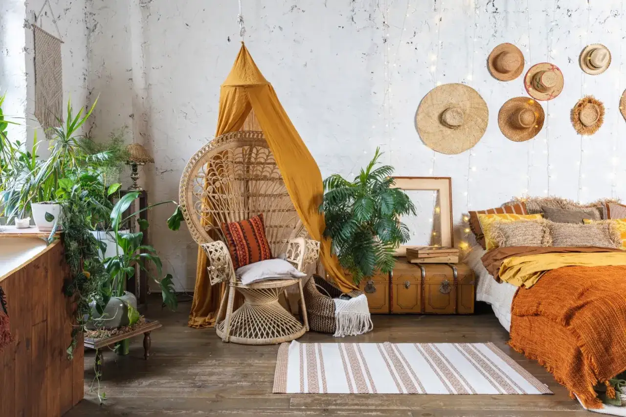 Un fauteuil en rotin, des plantes luxuriantes et une literie douillette cr&eacute;ent une ambiance style boho maison.