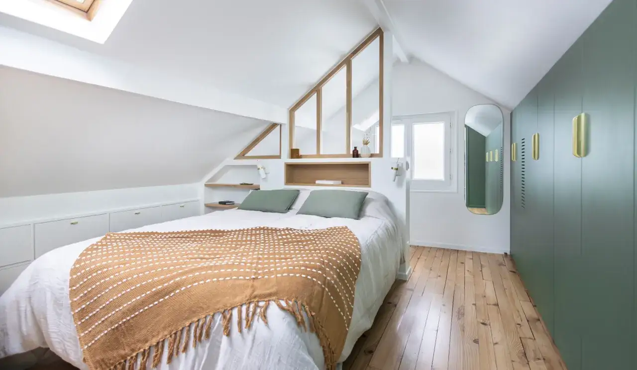 Suite parentale sous comble avec salle de bain et dressing. Un lit douillet, des rangements int&eacute;gr&eacute;s et une verri&egrave;re style atelier pour un espace cosy.
