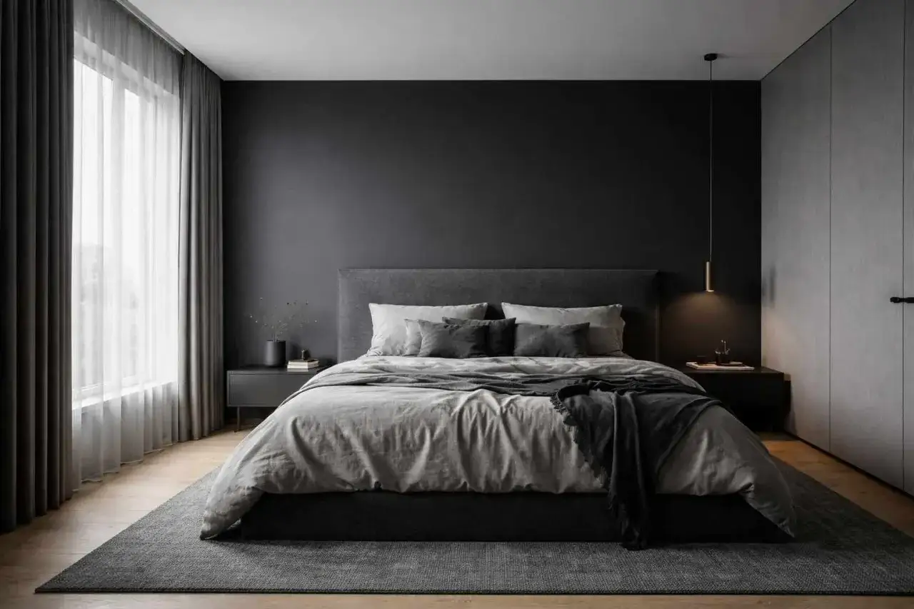 Une chambre grise moderne avec un lit douillet, des rideaux épais et une armoire intégrée. L'ambiance est apaisante et épurée.