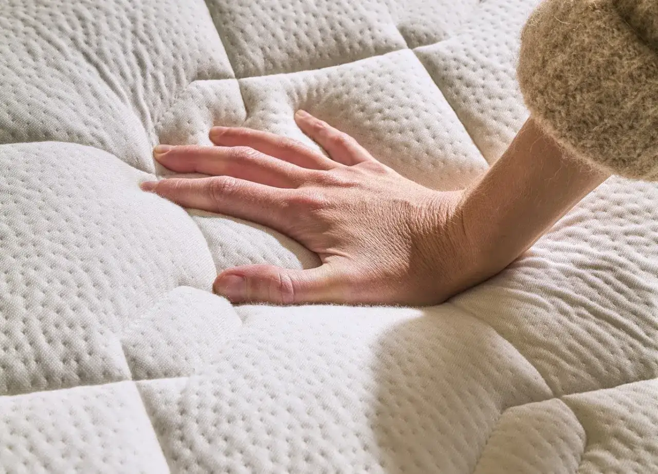 Main qui s'enfonce dans un matelas trop mou. Que faire pour retrouver un bon soutien ?