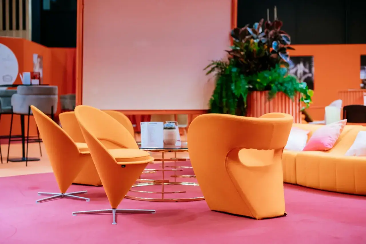 Ambiance pop avec ce mobilier années 70 caractéristiques : fauteuils orange vif, canapé modulable et table basse design.