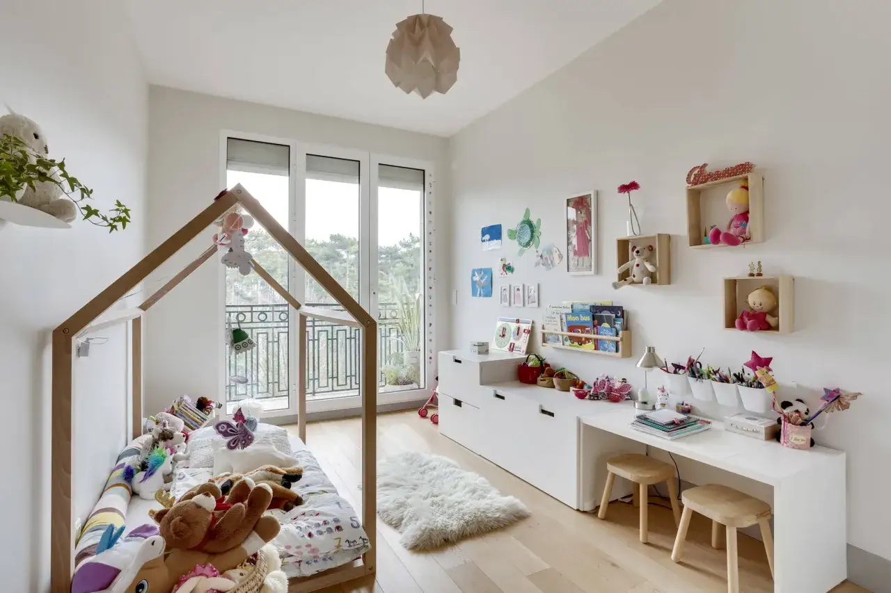 Une chambre d'enfant lumineuse avec un lit cabane, peluches, bureau et rangements. Une belle idee petite chambre bebe pour un espace joyeux et fonctionnel.