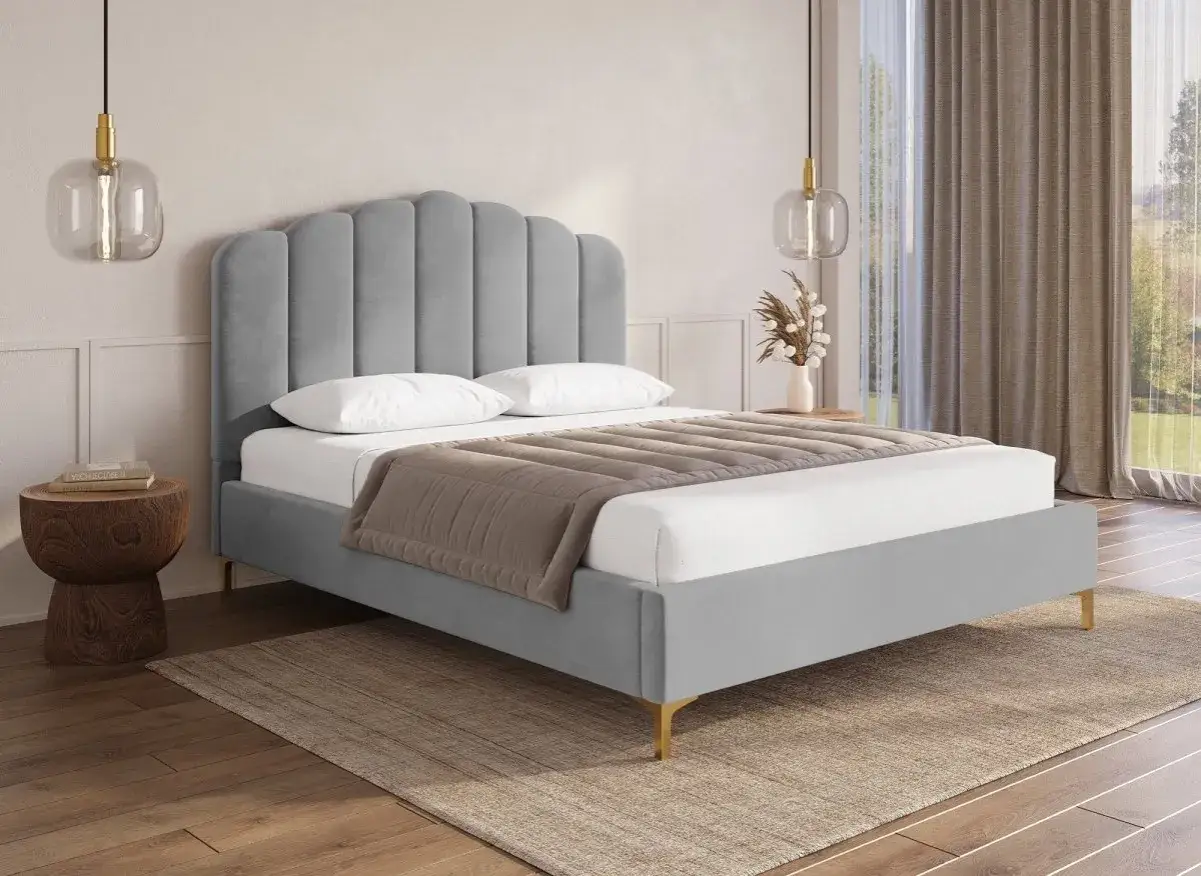 Lit 2 places gris avec tête de lit capitonnée, drap blanc, couverture beige, sur tapis et parquet.