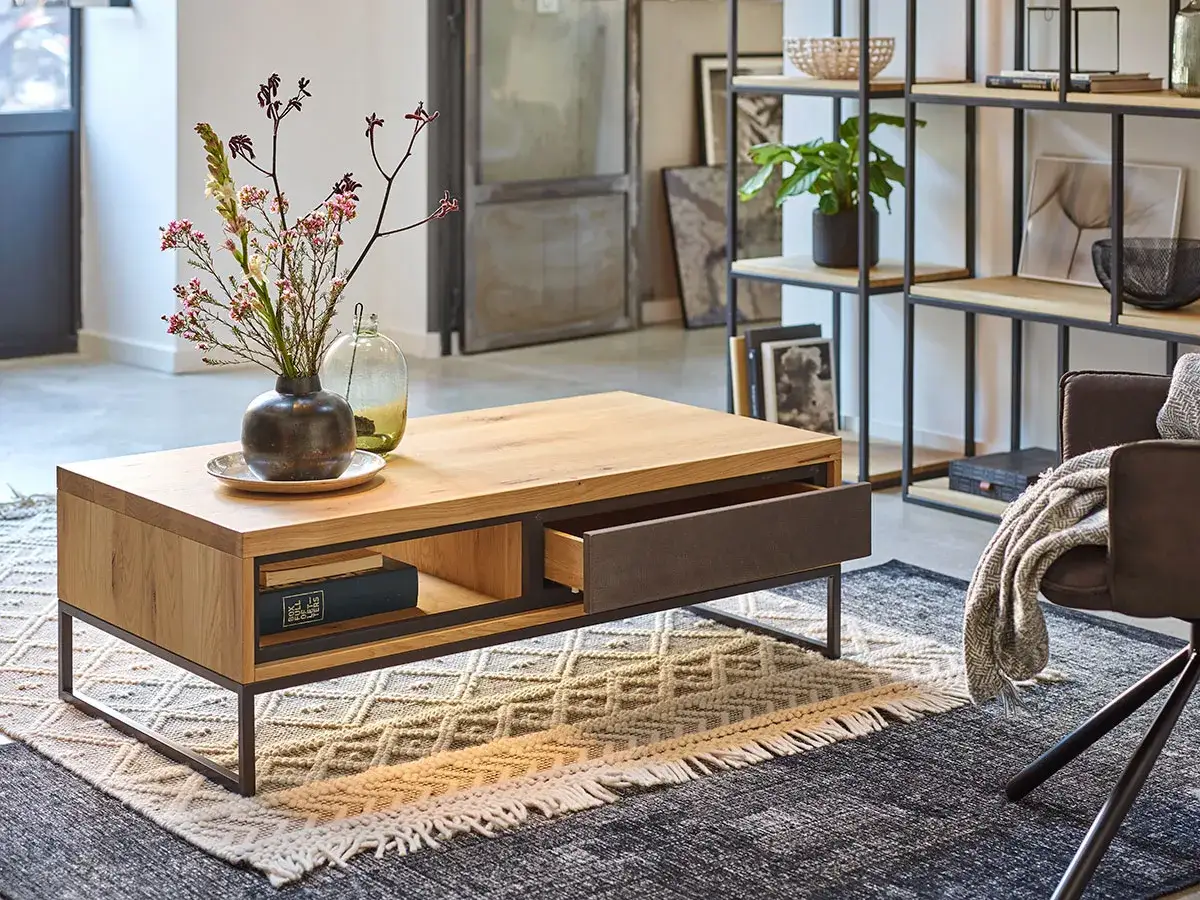 Table basse en bois et m&eacute;tal, avec un tiroir ouvert, un vase fleuri et une d&eacute;co murale. Une belle inspiration pour votre salon.